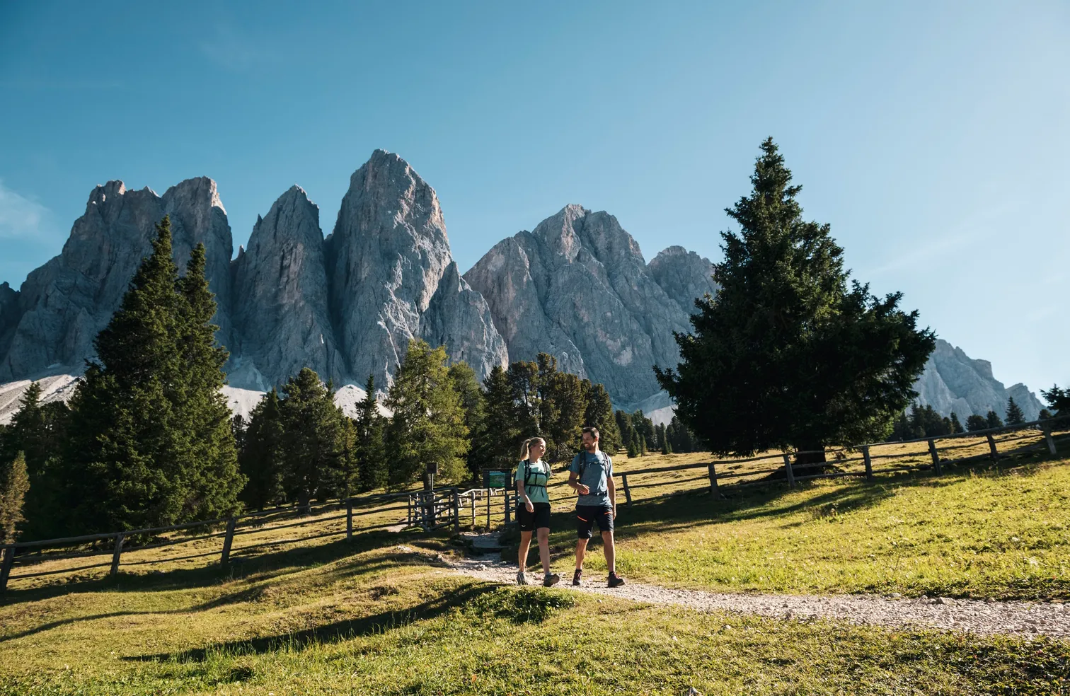 Hiker in front of the Geisler panorama in Puez-Geisler Nature Park – majestic Dolomite peaks in Villnöß