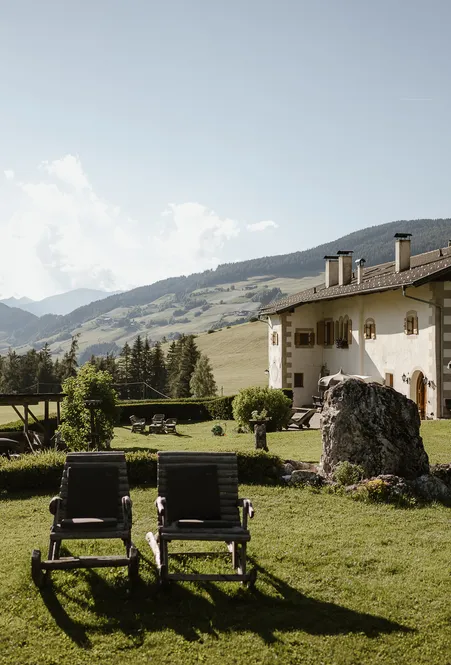 Romantisches Hotelzimmer in Villnöß mit traditionellem Südtiroler Holzmobiliar und Bergblick auf die Odles
