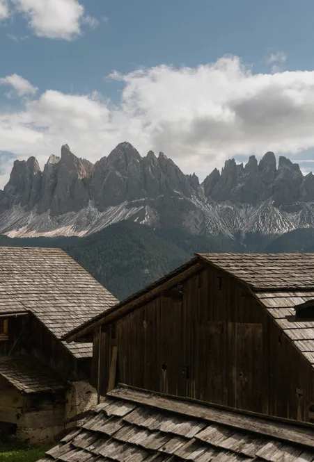 Frazione Coll a Funes: idillico paese di montagna con tipici masi altoatesini davanti al gruppo delle Odle