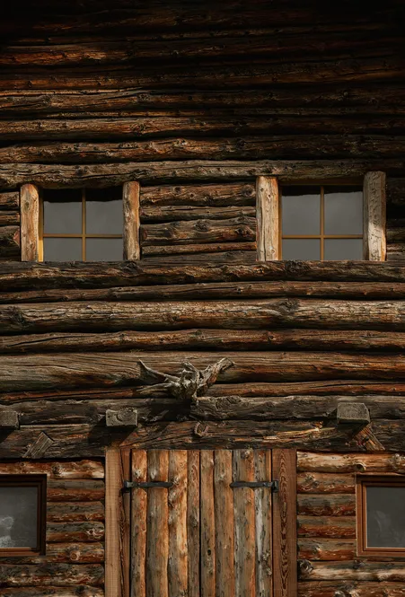 Tradizionale costruzione a tronchi altoatesina in legno tondo stagionato con finestre a battenti, Funes-Luson