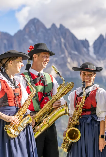 Wanderer genießen Herbststimmung im Villnößtal vor der majestätischen Geislergruppe bei St. Magdalena