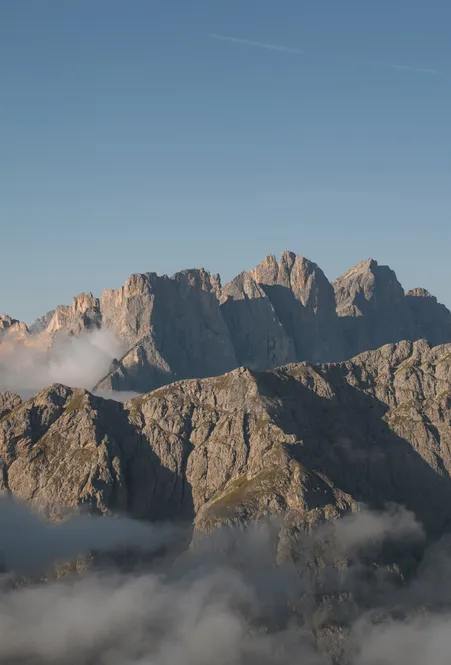 UNESCO-Welterbe Dolomiten: Panorama der Geislerspitzen im Naturpark Puez-Geisler bei Sonnenaufgang mit Nebelbänken