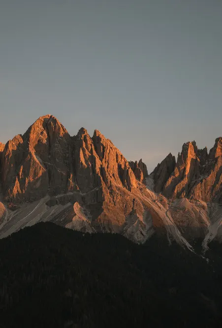 Enrosadira sul gruppo delle Odle – pinnacoli delle Odle risplendono arancio-rosso al tramonto sopra Funes