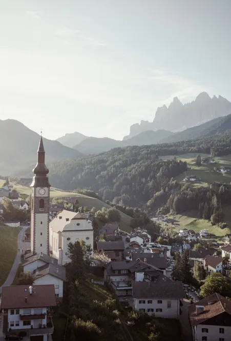 San Pietro a Funes: chiesa parrocchiale barocca con slanciato campanile, simbolo del comune nella Valle Isarco