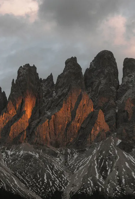 Enrosadira-Alpenglühen an den Geislerspitzen: Dolomitkalk leuchtet orange-rot beim Sonnenuntergang in Villnöß