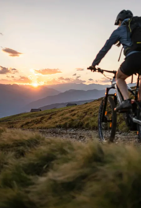 Cyclist on Luson Alp with panoramic view of Dolomite peaks in the background