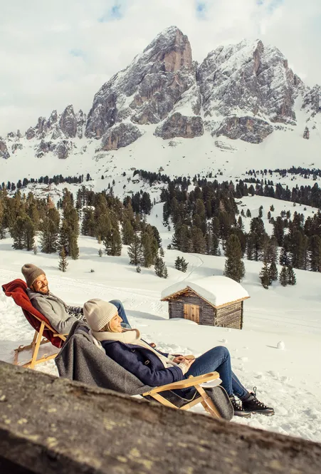 Winter panorama at Peitlerkofel with deck chair in snow – perfect break in the snow-covered Dolomites of South Tyrol