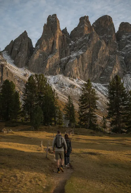 Female hiker on alpine meadow of Geisler Alm with majestic view of the Geisler peaks in summer green