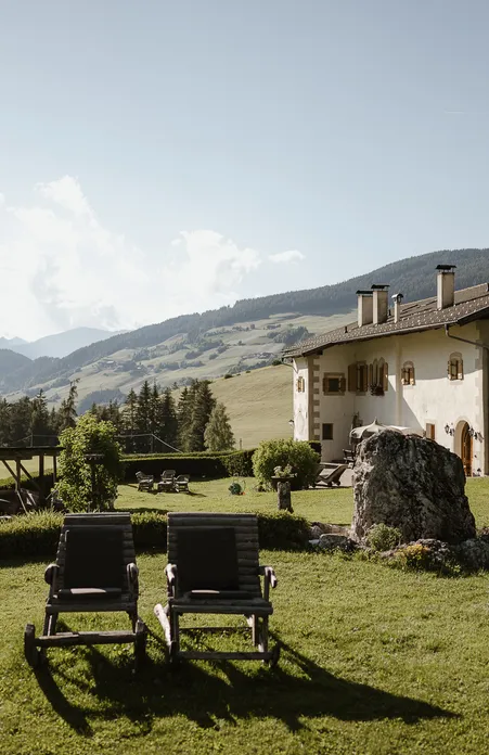 Romantisches Hotelzimmer in Villnöß mit traditionellem Südtiroler Holzmobiliar und Bergblick auf die Odles