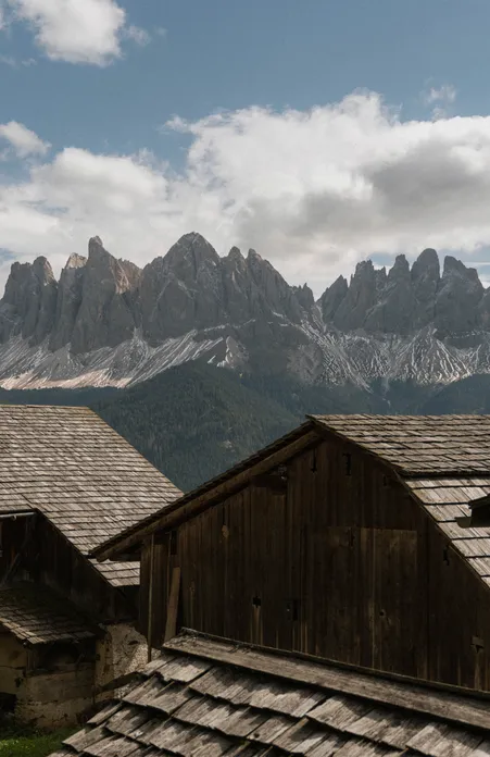 Frazione Coll a Funes: idillico paese di montagna con tipici masi altoatesini davanti al gruppo delle Odle