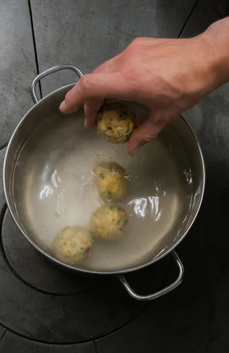 Hausgemachte Südtiroler Speck-Kräuter-Knödel werden traditionell im Topf gekocht