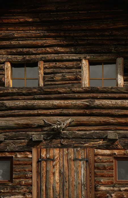 Traditioneller Südtiroler Blockbau aus verwittertem Rundholz mit Sprossenfenstern, Villnöß-Lüsen