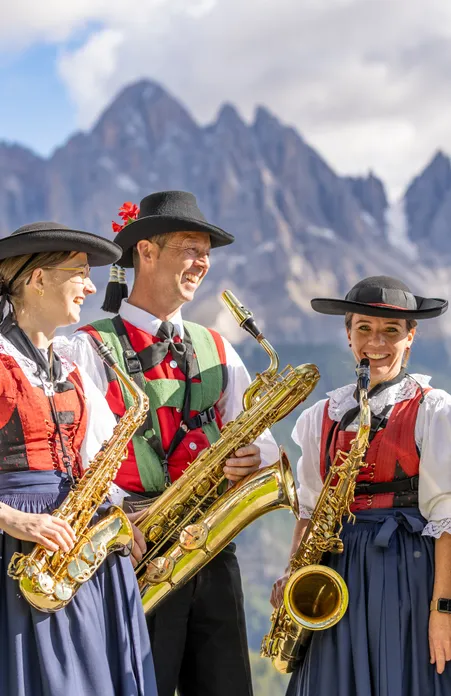 Wanderer genießen Herbststimmung im Villnößtal vor der majestätischen Geislergruppe bei St. Magdalena