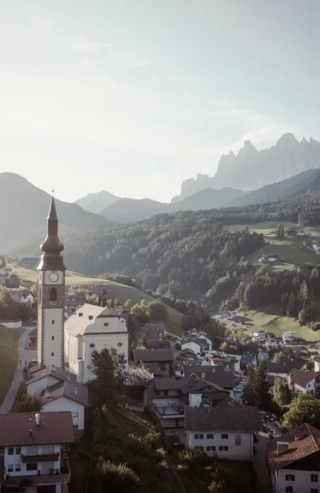 San Pietro a Funes: chiesa parrocchiale barocca con slanciato campanile, simbolo del comune nella Valle Isarco