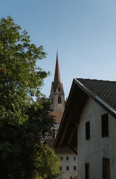 Tiso in Val di Funes: chiesa storica del paese e vigneti all'ingresso del Patrimonio Mondiale UNESCO Dolomiti