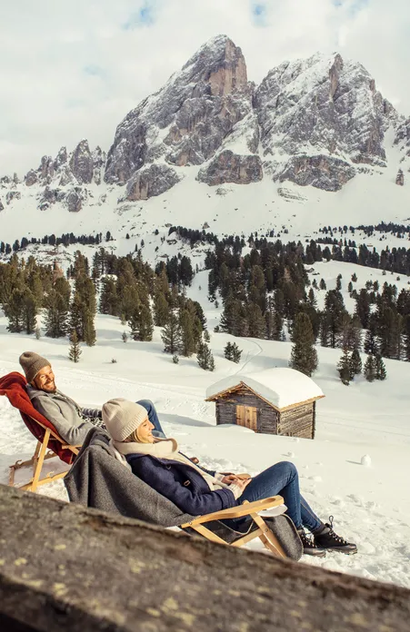 Winter panorama at Peitlerkofel with deck chair in snow – perfect break in the snow-covered Dolomites of South Tyrol