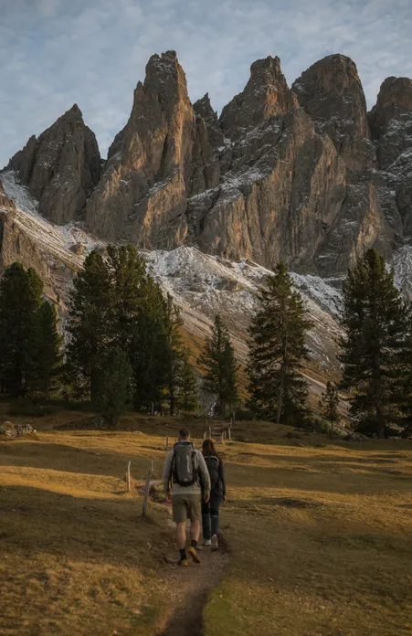 Escursionista su prato alpino della malga Geisler con vista maestosa sulle Odle nel verde estivo