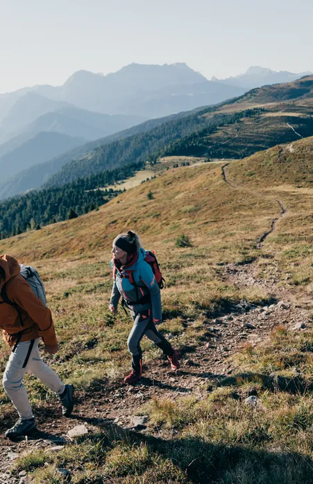 Escursionista sull'Alpe di Luson con panorama montano – paesaggio alpino idilliaco e vasti sentieri escursionistici in Alto Adige