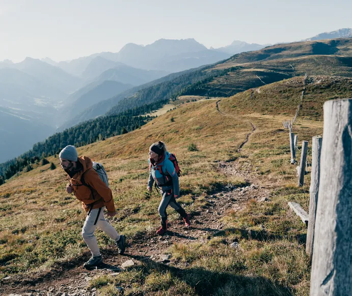 Hiker on Luson Alp with mountain panorama – idyllic alpine landscape and extensive hiking trails in South Tyrol